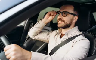 Man wearing glasses behind the wheel